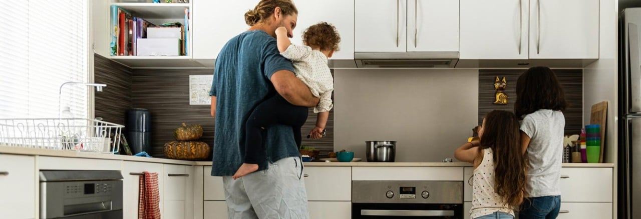 A young family in their kitchen at home.