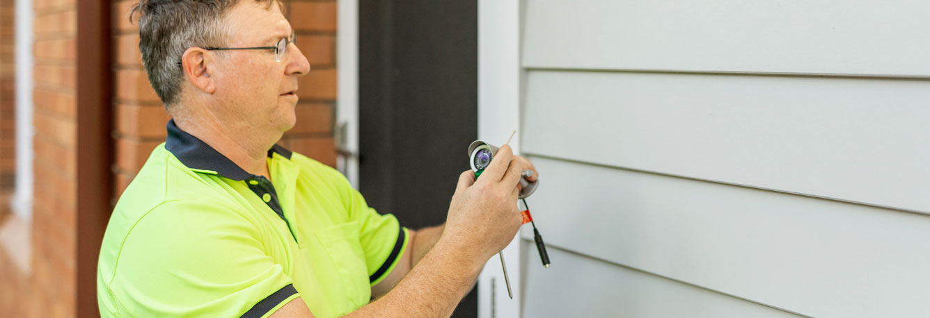 Installing a security camera outside the house.
