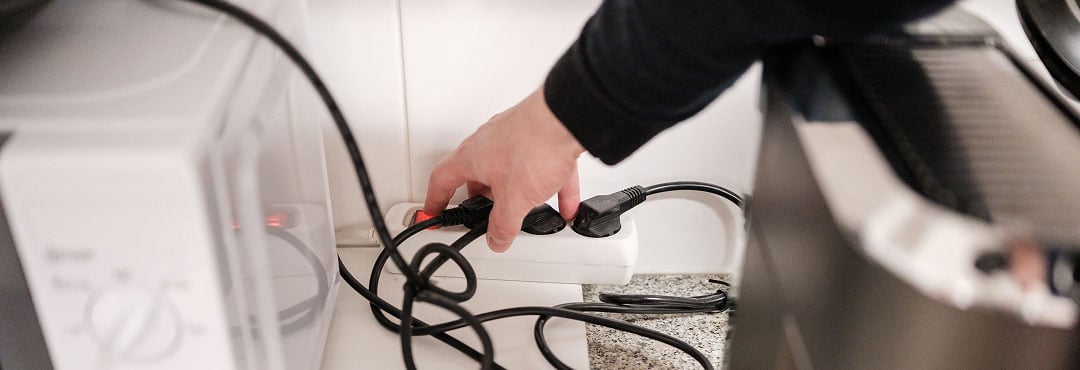 A homeowner using a plug-in protector for their microwave and air fryer.