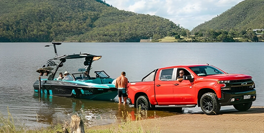 Utility vehicle launching a boat into a waterway