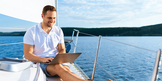 Man working on his laptop on a yacht