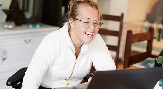 A young woman smiling on her laptop