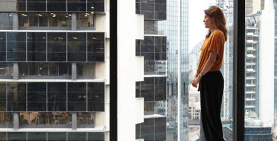 A woman lookes out a Sydney office window