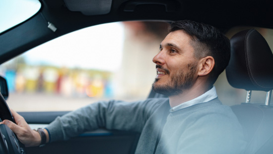 smiling male in drivers seat motor vehicle
