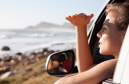 Woman in a car looking at the ocean