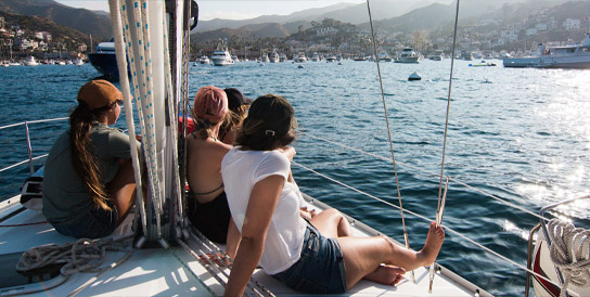 A group sitting on a boat deck looking at the view