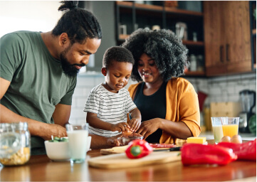 A young family in the kitchen making lunch.